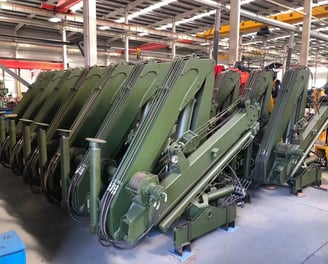 Customer order: Green SQZ68A.2 folding boom cranes at our truck-mounted crane manufacturing facility.
