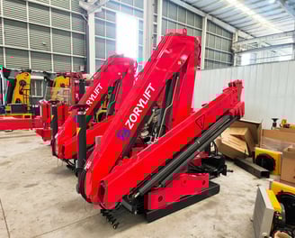 Factory floor: Black SQZ132A.3 knuckle boom cranes awaiting final assembly for customer order.