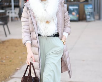 a woman in a white coat and a brown bag