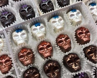 Handcrafted white, milk, and dark chocolates inspired by Day of the Dead featuring festive and traditional designs