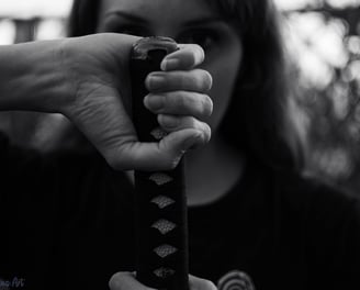 a woman holding a katana and a katana in her hand