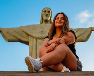 turista posando aos pés do cristo redentor