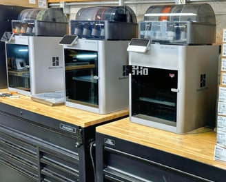 bunch of 3d printers on the bench