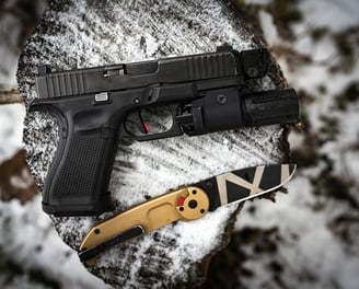 Glock pistol and knife on snow covered tree stump