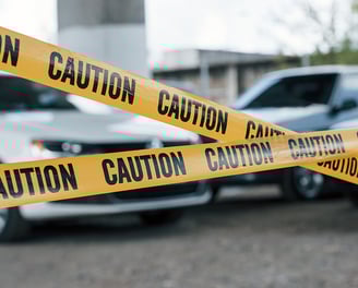 Police tape strung up across a crime scene in front of a parking lot