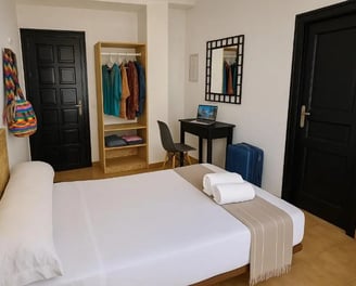 Habitación estándar del Hotel San Vicente en Conil, con cama doble, escritorio con portátil, armario