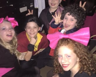 a group of kid actors posing for a picture backstage connecting as friends.
