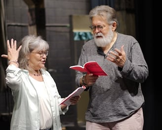 a man and woman standing in front of a stage