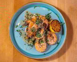 King prawns on a blue plate with lemon