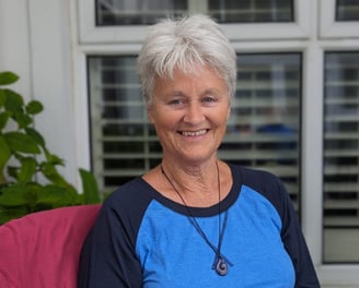 a woman sitting on a couch with a necklace necklace