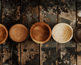 a row of wooden bowls with wooden bowls on them