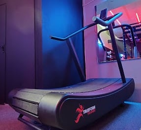 A treadmill shot from a low angle with a mirror and blue light in the background