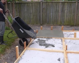 Pouring concrete manually in a concrete patio