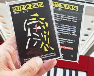 foto de uma mão segurando dois pacotes da série arte de bolso.