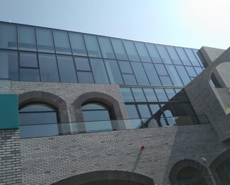a building with a clock towering over a brick wall