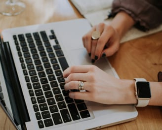 a hand typing on a modern laptop