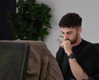 a man sitting at a desk with a laptop computer
