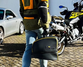 Remy helmet bag resting on a parked motorcycle, highlighting premium design and real-world use