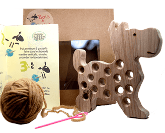 a wooden toy dog with a ball of yarn