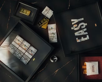 frames and artwork with money and gold bar in a marble background