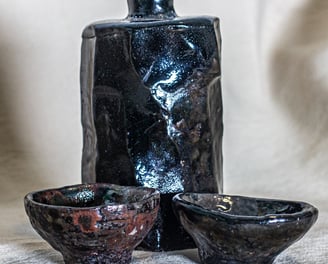 Kurinuki Raku sake set made in Amman, Jordan, hand-carved with black glaze and earthy red tones