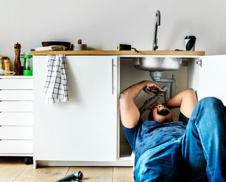 A plumber fixing a domestic kitchen sink