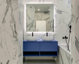 a bathroom with a marbled floor and a blue vanity