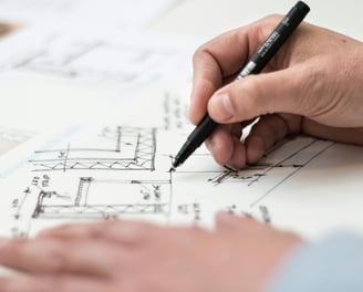 a person is holding a pen and writing on a paper