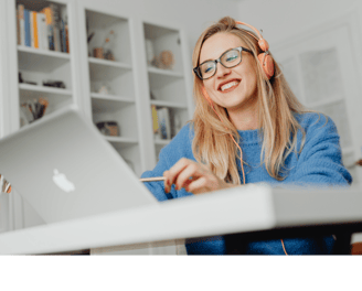 a woman wearing a blue sweatshirt and headphones, sitting at a desk