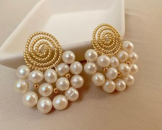 a pair of earrings with pearls and gold