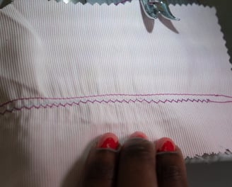 Straight stitch parallel to zig zag stitches shown on pink fabric