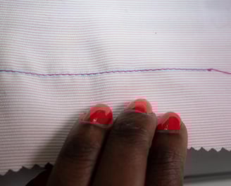 Straight stitches shown on pink fabric