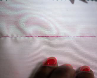 Basting stitch on pink fabric