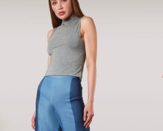 Woman wearing a grey tank top with blue pants