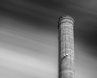 Prominent Georgetown Tx smokestack stands against a streaked cloud sky