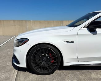 White Mercedes C63s side profile with black AMG wheels