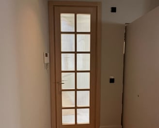 Puerta de madera con cristales, pasillo, suelo de madera.