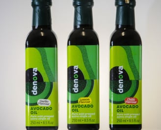 three bottles of Denovoa Avocado oil on a table