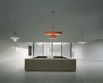 Lámparas técnicas suspendidas en espacio arquitectónico minimalista con luz natural