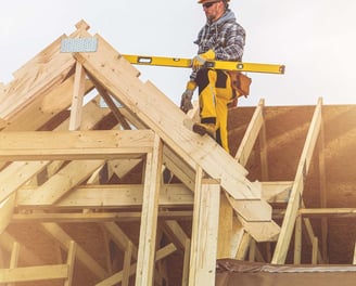 a construction worker on a roof top with a level level of construction