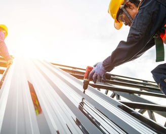 two workers working on a roof top of a building