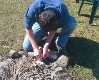 teenager making a campfire at teencampsuk