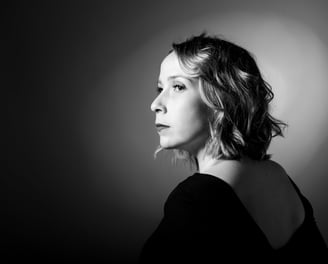 Photo en noir et blanc d'une femme de profil sur fond noir avec halo