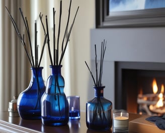 A collection of artisan candles with dried flowers and herbs embedded in the wax is arranged on a wooden surface. The candles vary in size, with some in glass containers. The dried flowers include lavender and rose petals, adding a rustic and handmade aesthetic. Soft lighting enhances the warm and cozy atmosphere.