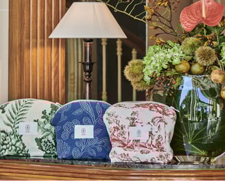 Pochettes ÉTOFÉ en tissu upcyclé, exposées dans un décor d’hôtel raffiné, motifs feuillage, broderie