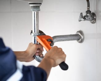 o imagine cu un instalator strangand de o teava