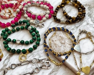 a bunch of bracelets with a variety of beads and charms