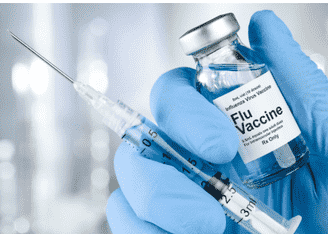a person in gloves holding a flu vaccine and a syringe