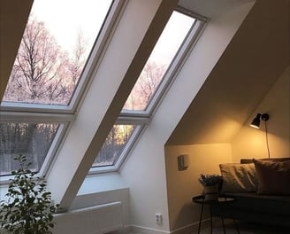 Technicien professionnel nettoyant une fenêtre de toit Velux avec des outils spécialisés