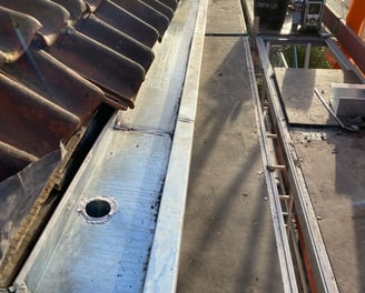 a roof top with a metal pipe and a metal pipe